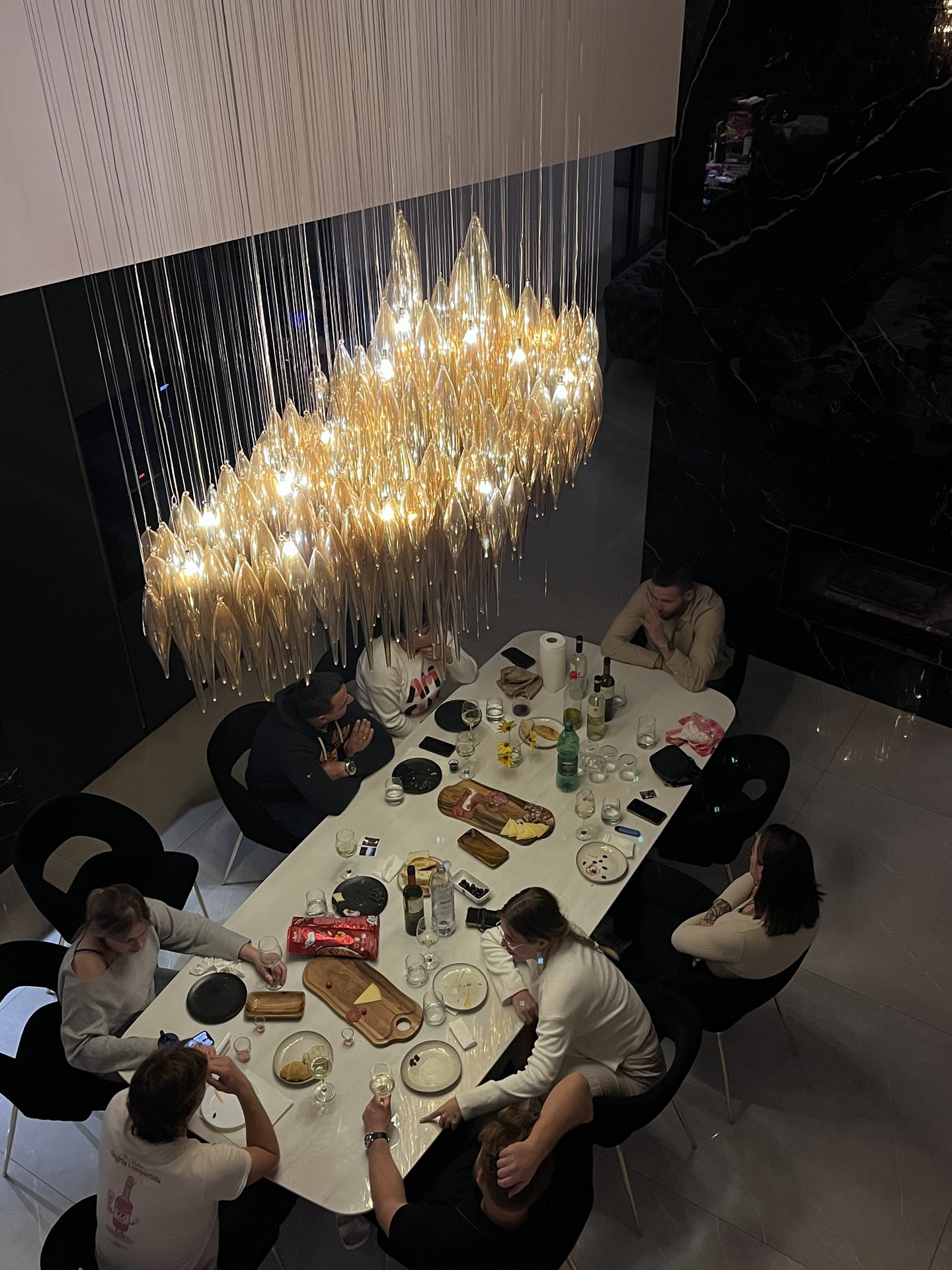 The Bloqq team around a dinner table under an amber chandelier